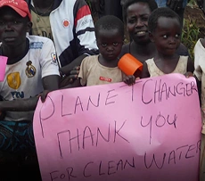 Community members holding a "Planet Changer Thank You for Clean Water" sign