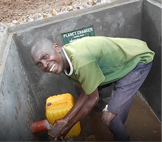 Resident collecting clean water from a newly built community water source