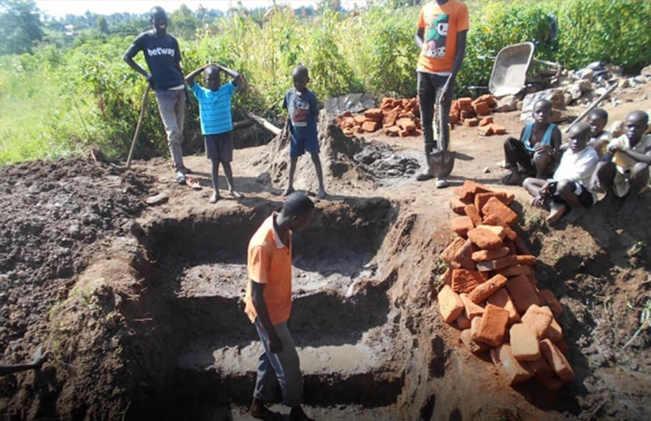 Volunteers and community members building a clean water well