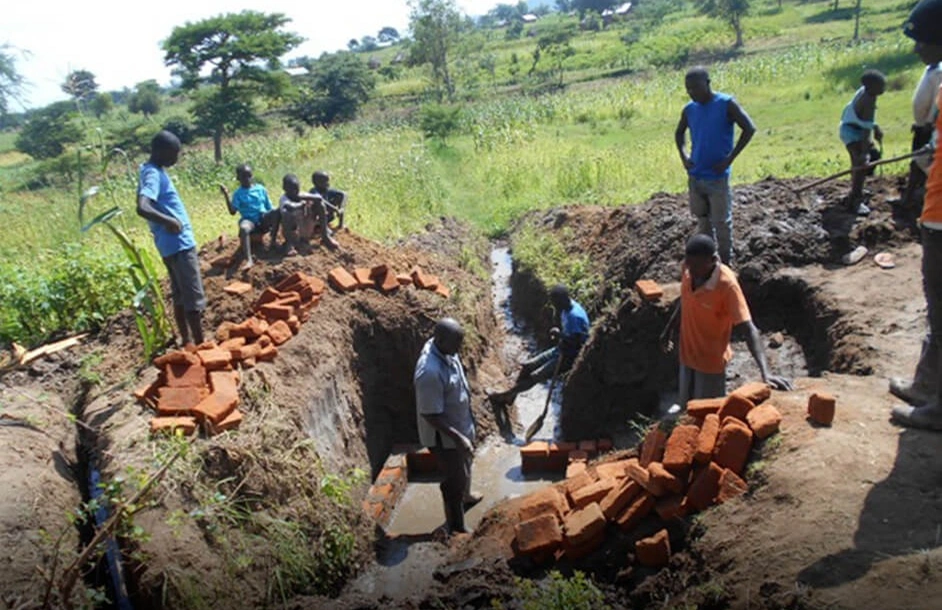 Community volunteers working together on a clean water well project