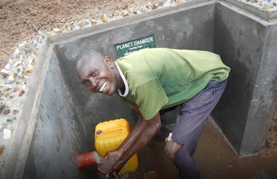 Volunteer helping construct a clean water well in Uganda